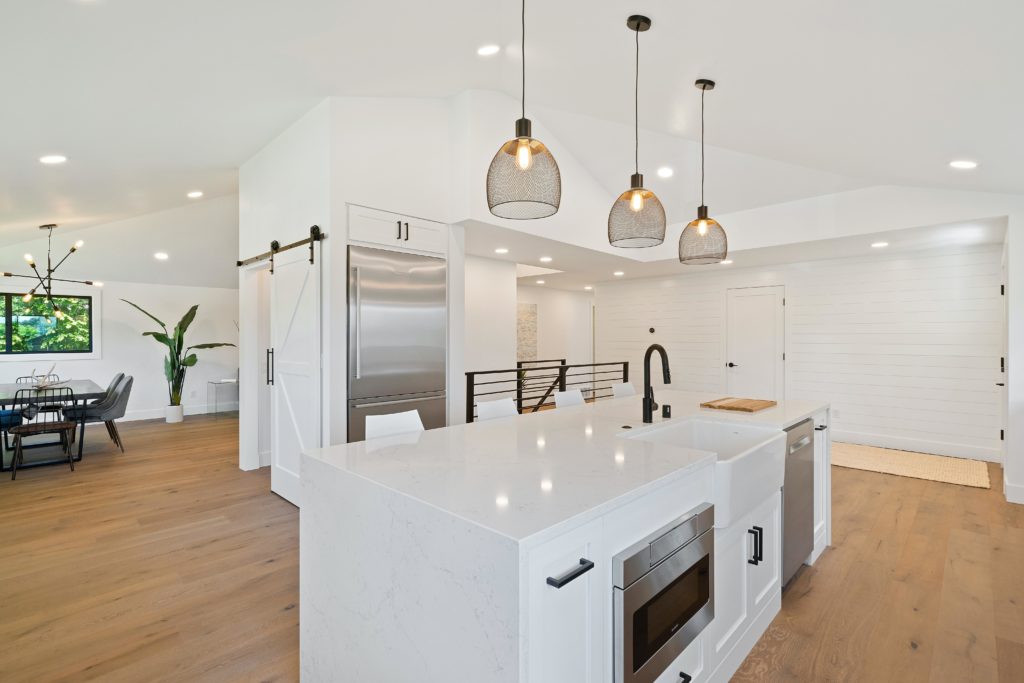 modern white kitchen with an island and overhanging lights